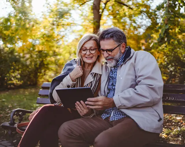 couple senior people happy seated in a bench autumn